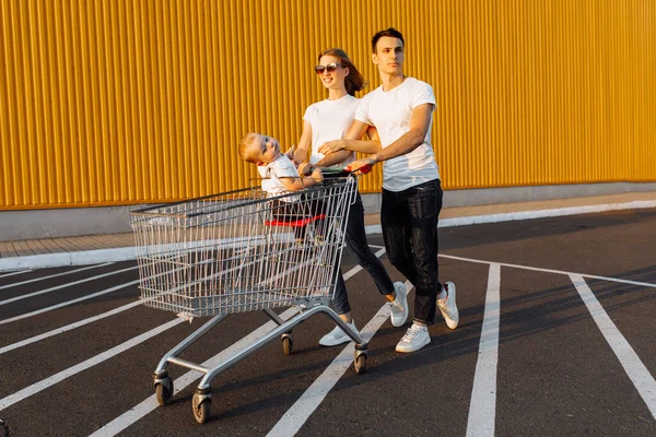 快乐的家庭 快乐的男人和女人在购物车里 在户外 在购物的概念里玩耍 — 图库照片