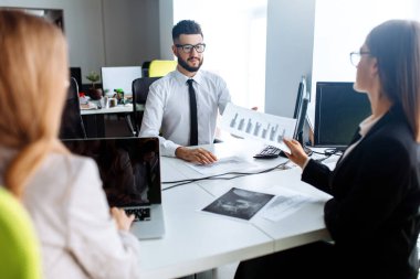 İş ortakları ofiste bir toplantıda belge ve fikirleri tartışıyor, iş konsepti