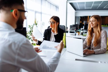 İş adamları. Bir grup kendine güvenen iş adamı masadaki ofiste dizüstü bilgisayar ve iş konseptiyle birlikte çalışıyorlar.
