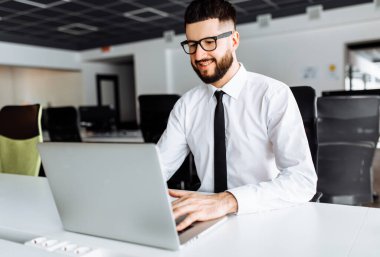 Ofiste çalışırken dizüstü bilgisayar kullanan başarılı bir iş adamı, iş konsepti