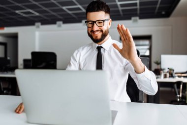 İş adamı web konferansında iş arkadaşlarıyla konuşuyor. Bilgisayar kamerası kullanıyor. Erkek çalışan iş arkadaşlarıyla görüntülü konuşma yapıyor.