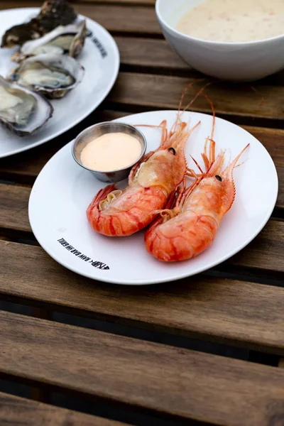 taze deniz ürünleri, istiridye ve karides, terasta bir kafede ahşap bir masada