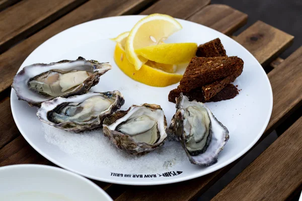 fresh seafood, oysters and shrimps, on a wooden table in a cafe on the terrace