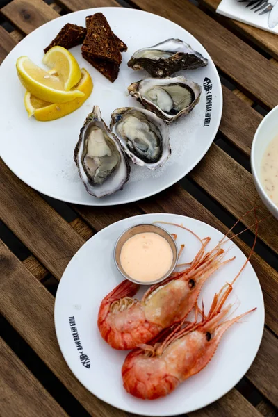 fresh seafood, oysters and shrimps, on a wooden table in a cafe on the terrace, flat lay