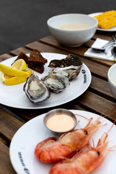 fresh seafood, oysters and shrimps, on a wooden table in a cafe on the terrace
