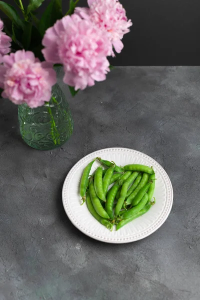 koyu arka planda pembe şakayık çiçeği buket, yeşil bezelye