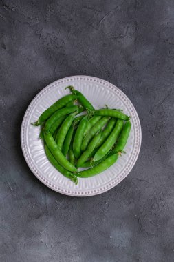 taze yeşil bezelye, seramik beyaz plaka
