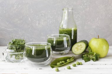 İki bardak bir close-up salatalık, elma ve Beyaz ahşap zemin üzerine nane taze sıkılmış meyve suyu ile. Alan, seçici odak sığ derinliği