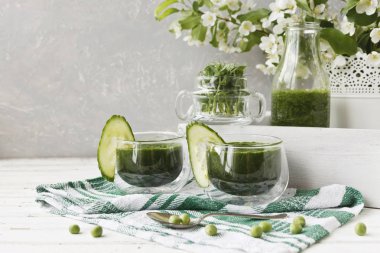 İki bardak bir close-up salatalık buz ve Beyaz ahşap zemin üzerine nane taze yeşil ev yapımı meyve suyu ile. Alan, seçici odak sığ derinliği