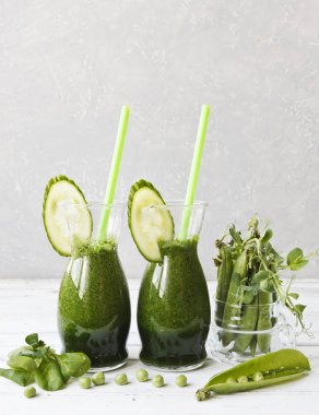 Ev yapımı yeşil smoothie Close-up taze ıspanak, bezelye ve salatalık Beyaz ahşap zemin üzerinde yapılan