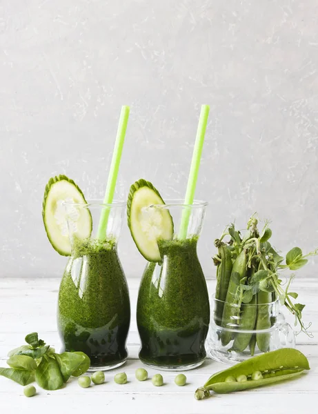 Ev yapımı yeşil smoothie Close-up taze ıspanak, bezelye ve salatalık Beyaz ahşap zemin üzerinde yapılan