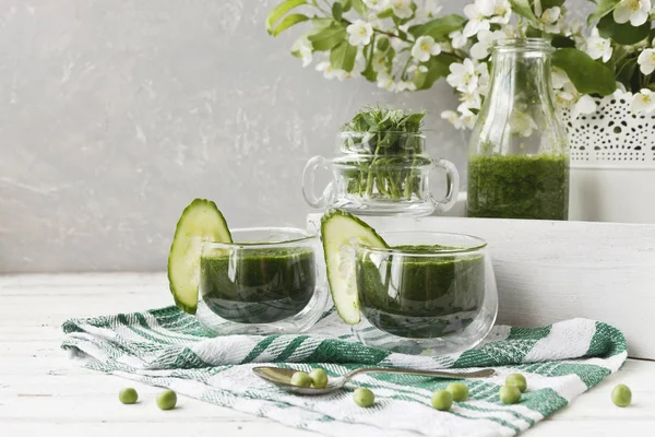 Ev yapımı yeşil smoothie Close-up taze ıspanak, bezelye ve salatalık Beyaz ahşap zemin üzerinde yapılan