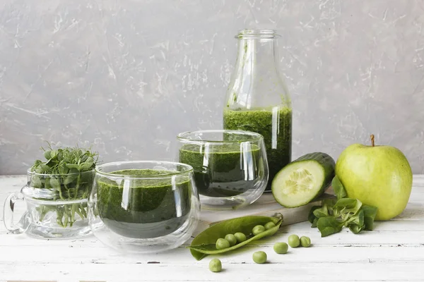 Ev yapımı yeşil smoothie Close-up taze ıspanak, bezelye, salatalık ve elma Beyaz ahşap zemin üzerinde yapılan