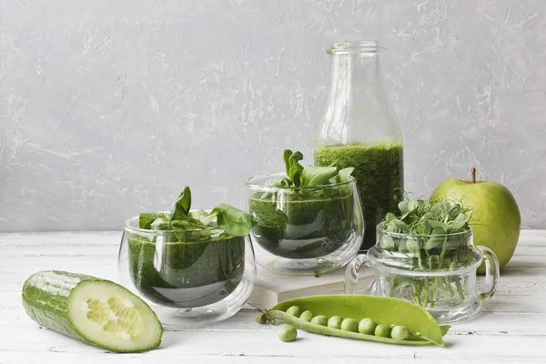 Ev yapımı yeşil smoothie Close-up taze ıspanak, bezelye, salatalık ve elma Beyaz ahşap zemin üzerinde yapılan
