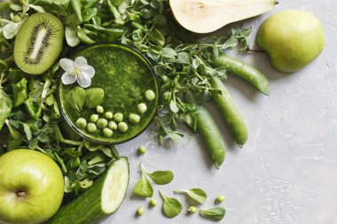 Gri arka plan üzerinde taze armut, bezelye, salatalık, kivi ve elma ile ev yapımı Yeşil yüzlü üstten görünüm. 