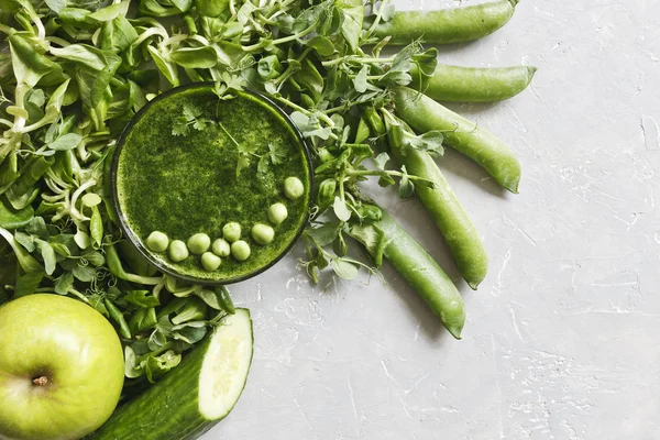 Gri arka plan üzerinde taze ıspanak, bezelye, salatalık ve elma ile ev yapımı Yeşil yüzlü üstten görünüm. 