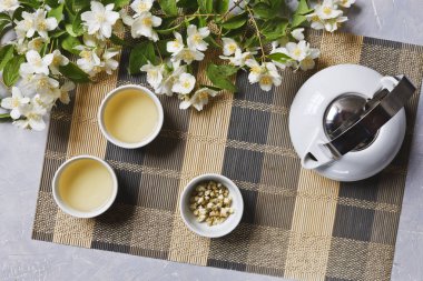 Beyaz porselen Asya çay seti ile yeşil çay ve yasemin bambu peçete, üstten görünüm üzerinde.