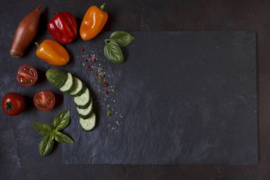 Siyah taş kesme tahtası üzerinde taze sebze yakın çekim fotoğraf.