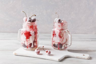 Dondurma cam bardağı Dondurulmuş vişne ile iki porsiyon. Açık renkli yakın çekim.