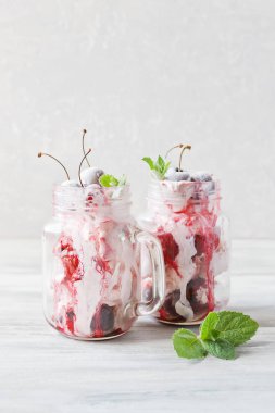 Dondurma cam bardağı Dondurulmuş vişne ile iki porsiyon. Açık renkli yakın çekim.