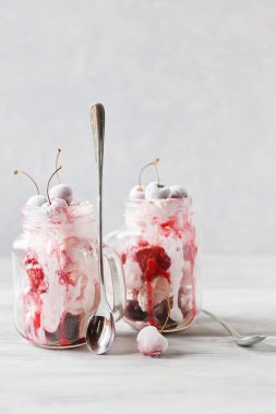 Dondurma cam bardağı Dondurulmuş vişne ile iki porsiyon. Açık renkli yakın çekim.