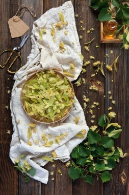  Ihlamur çiçek ve güzel kokulu bir cam şişe özünde. Bitkisel ilaç, spa ve sauna için aksesuarlar. Antika ahşap rustik arka plan üzerinde üstten görünüm.