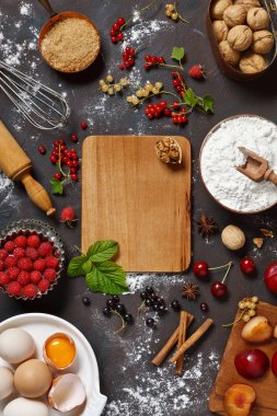 Un, yumurta, baharatlar, taze meyveler ve karanlık taş masa ahşap tahta