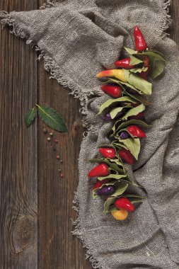 Pul biber, defne yaprakları ve zeytinyağı üstten görünüm ahşap rustik zemin üzerine