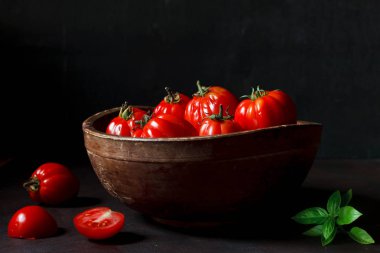 Antika ahşap kase koyu arka plan üzerinde olgunlaşmış taze domates fotoğraf kapatmak