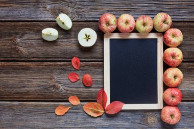 Taze kırmızı elma, kırmızı yaprakları ve ahşap arka plan boş tahta