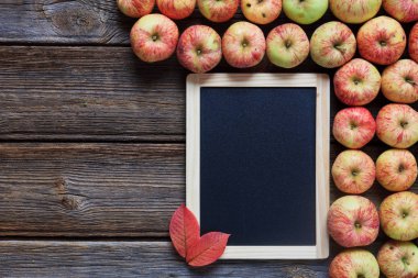 Taze kırmızı elma, kırmızı yaprakları ve ahşap arka plan boş tahta