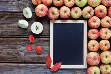 Taze kırmızı elma, kırmızı yaprakları ve ahşap arka plan boş tahta