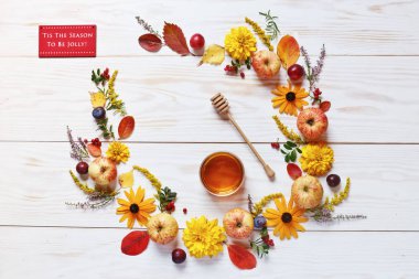 Apples, plums, red berries, honey and beautiful flowers on white wooden background with copy space. Summer harvest concept  clipart