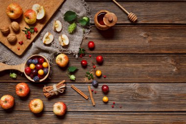 Harvest Festival - Fresh juicy apples, wild cherry plums, honey and walnuts on a vintage wooden background. Top view, close-up. clipart