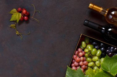 Kırmızı, yeşil ve mavi üzüm yaprakları metal kutu ve iki şişe şarap ile