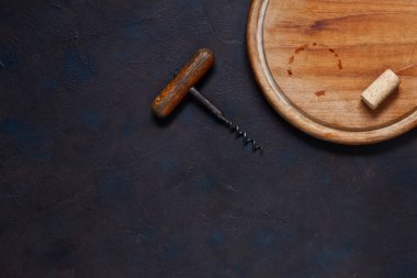 Mantar ve tirbuşon vintage koyu arka plan üzerinde ahşap kesme tahtası ile. Üstten görünüm, yakın çekim 