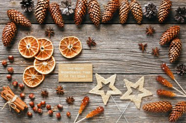 Koniler, Kuru portakal dilimleri, Anason yıldız ve tarçın ahşap masa, üstten görünüm üzerinde Noel arka plan