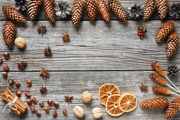 Christmas  background  with cones, dry orange slices, anise stars and cinnamon sticks on wooden table, top view