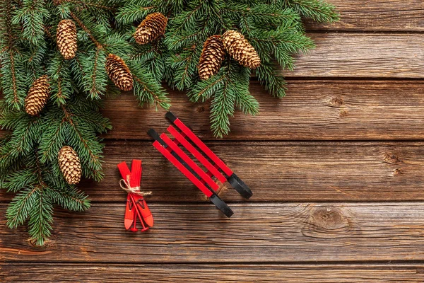 モミの木の枝 スキーやソリ木製テーブルの上にクリスマスの背景 — ストック写真