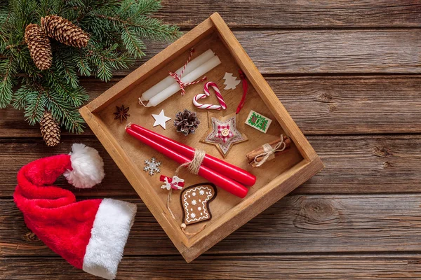 圣诞节背景与冷杉树分支 圣诞老人帽子 圣诞节蜡烛和装饰在木箱里 — 图库照片