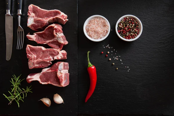 Costelas Temperos Carne Cordeiro Fresca Crua Fundo Pedra Preta — Fotografia de Stock