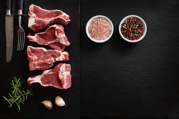 Costelas Temperos Carne Cordeiro Fresca Crua Fundo Pedra Preta — Fotografia de Stock