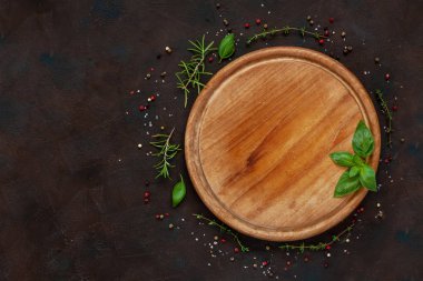 Condiments and spices on round wooden board on vintage wooden background. Top view
