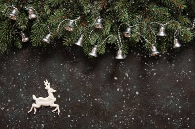Köknar ağacı dalları, Noel çanları garland, geyik, kar ve kar taneleri ile Noel arka plan. Kopya alanı ile üstten görünüm