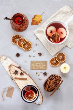 Baharatlar ve gri beton zemin üzerine malzemeler ile büyük kupa sıcak Mulled şarap. Sonbahar kavramı. Görünüm sayfa, yakın çekim, lay düz. Metniniz için kopya alanı.