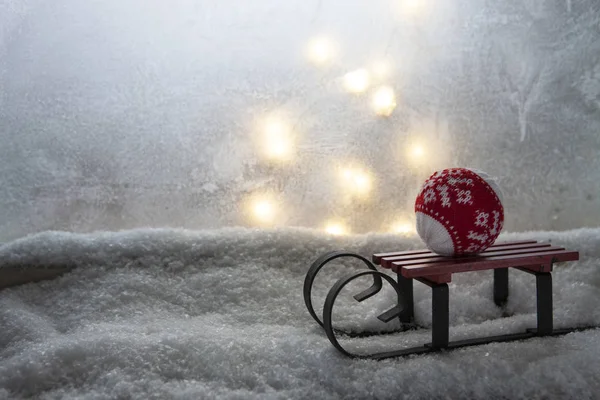 雪で覆われた窓枠にクリスマス ボールと小さいおもちゃ用そり — ストック写真