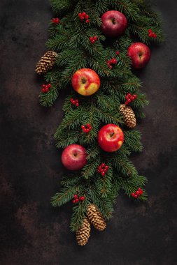 Köknar ağacı dalları ve koniler ile kırmızı meyveler ve koyu arka plan üzerinde kırmızı elma ile Noel tatil arka plan. Üstten görünüm, Noel ve yılbaşı konsepti