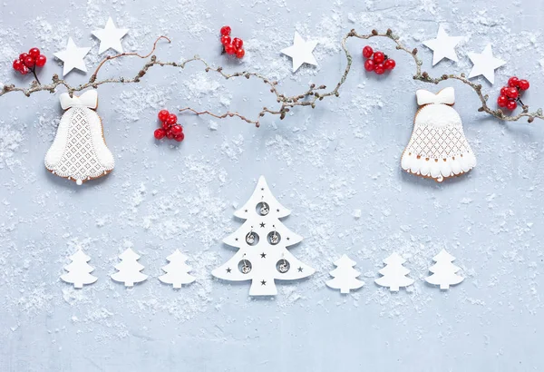 圣诞节假期背景与树枝和红色浆果姜饼和圣诞节装饰在浅灰色的背景与雪 新年的概念 生物和生态材料 — 图库照片