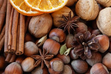 Ceviz, fındık, tarçın soyulmuş kabuk, dilim kuru turuncu ve baharat görünümü Kapat 