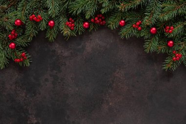 Noel tatili köknar ağacı ile arka plan kırmızı meyveler ve top dalları. Üstten görünüm, karanlık beton arka plan yakından. 